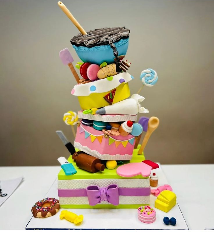 Colorful 3D sculpted artistic cake with edible tools and candy accents