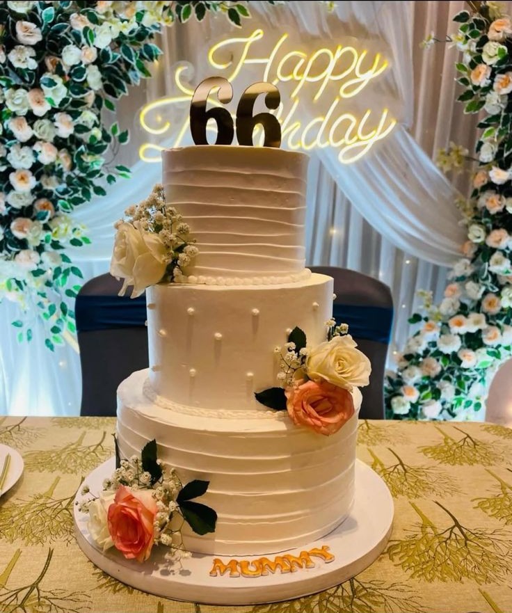 Elegant white multi-tier milestone birthday cake with floral accents